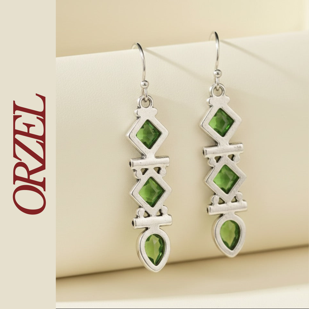 Boucles d’oreilles pendantes argentées avec pierres vertes géométriques.