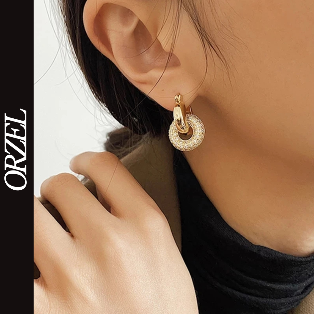 Boucles d’oreilles torsadées – style punk chic avec zircons brillants.