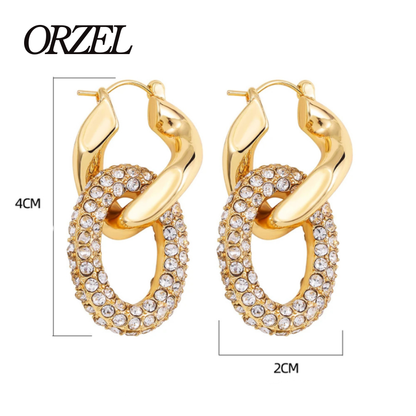Boucles d’oreilles torsadées – style punk chic avec zircons brillants.