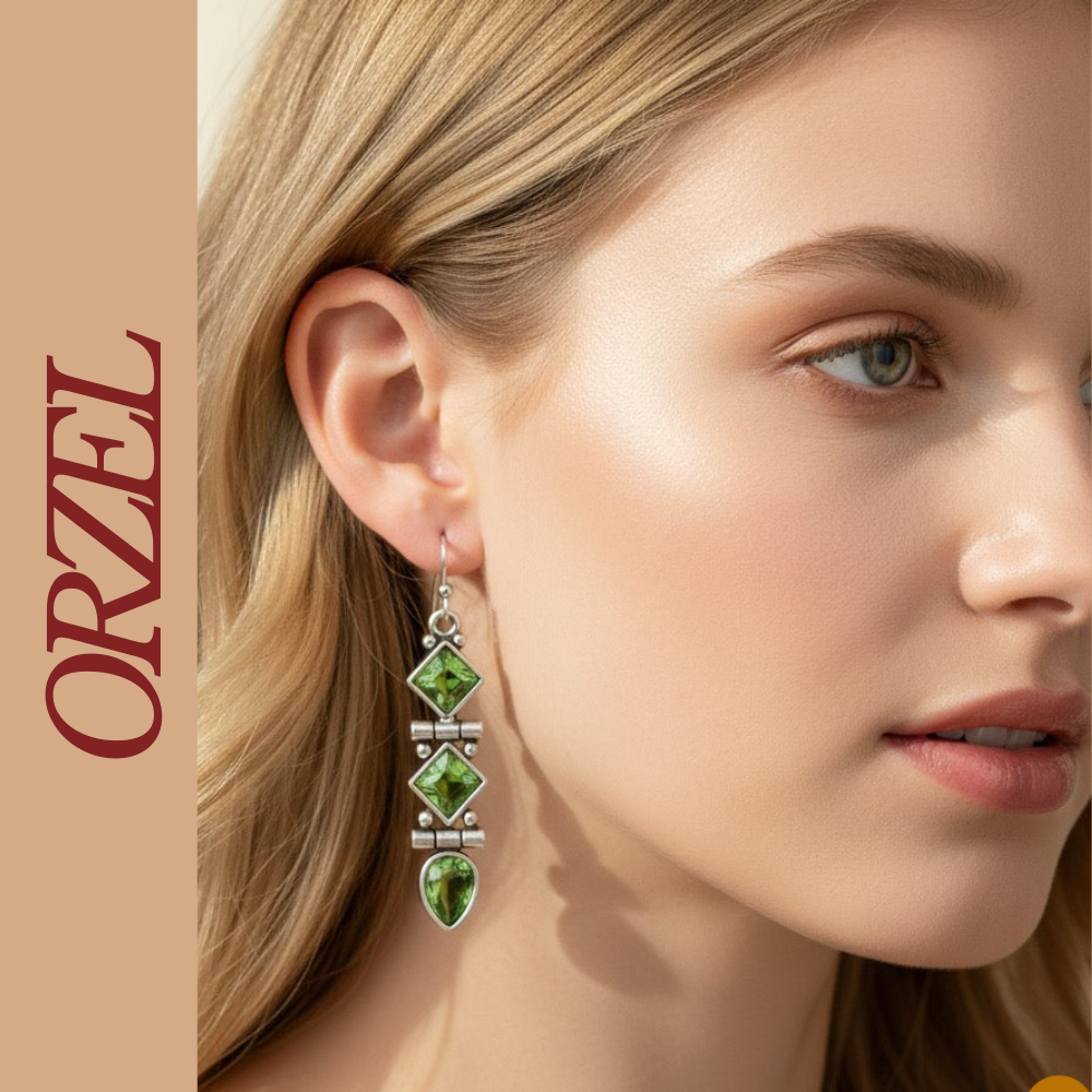 Boucles d’oreilles pendantes argentées avec pierres vertes géométriques.