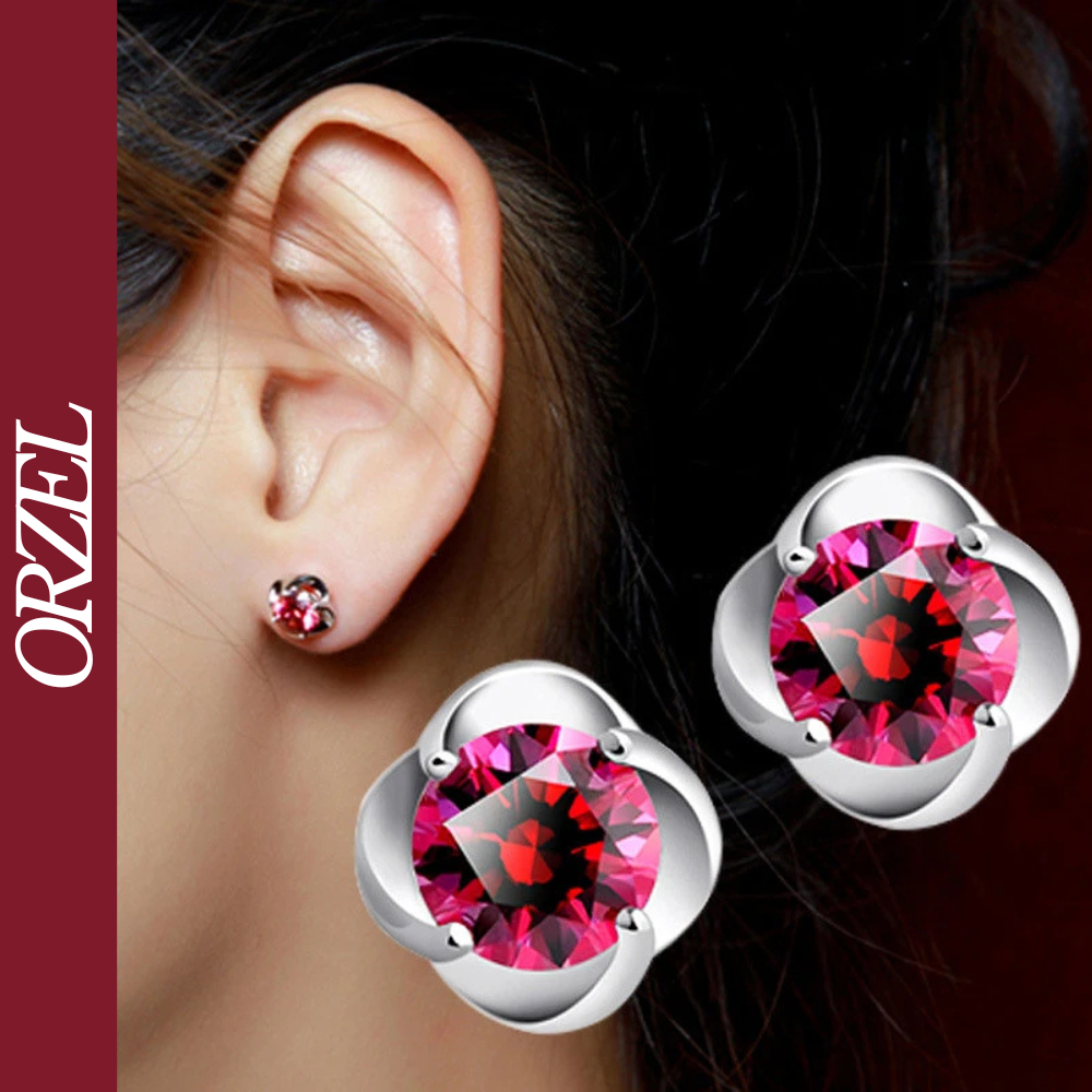 Boucles d’oreilles clous argentées avec pierre rouge.