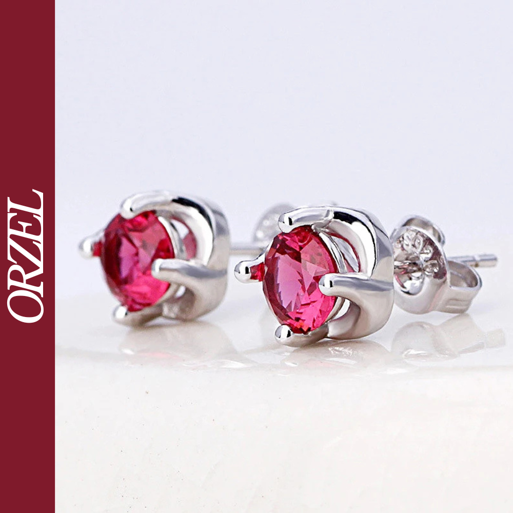 Boucles d’oreilles clous argentées avec pierre rouge.