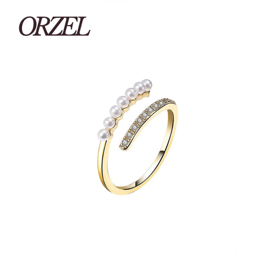 Bague ouverte dorée avec perles et cristaux.