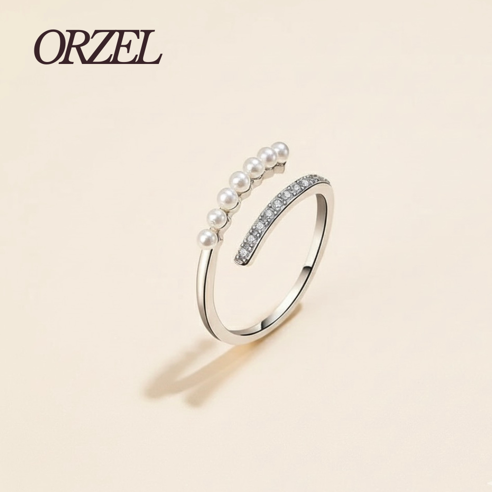 Bague ouverte dorée avec perles et cristaux.